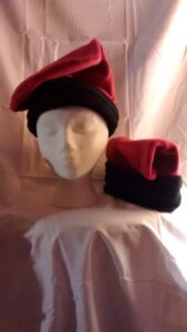foto de dos barretinas catalanas, sombreros de felpa (felt) con la parte superior roja y una banda negra donde toca la cabeza