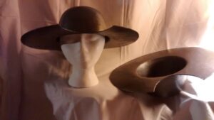 foto de una reproducción del "yelmo" de don Quijote, que es un basín de barbero (barber's basin) invertido (turned upside down) con un hueco en el ala (gap in the brim) que servía para acercar el cuello del cliente al basín y permitir que se lavara su barba (allow his beard to be washed)