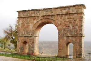 El arco triunfal de Medinaceli en Soria tiene un arco principal, muy grande, en el centro y dos arcos más pequeños a cada lado. Se notan restos encima de los arcos más pequeños donde habrían estado unas esculturas de relieve. Los arcos tienen la forma semicircular y la estructura entera tiene proporciones armónicas rectangulares.