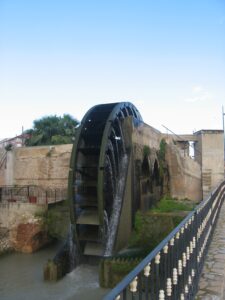 Foto de una noria diseñada por los árabes medievales; es una gran rueda que mueve en la corriente de agua.