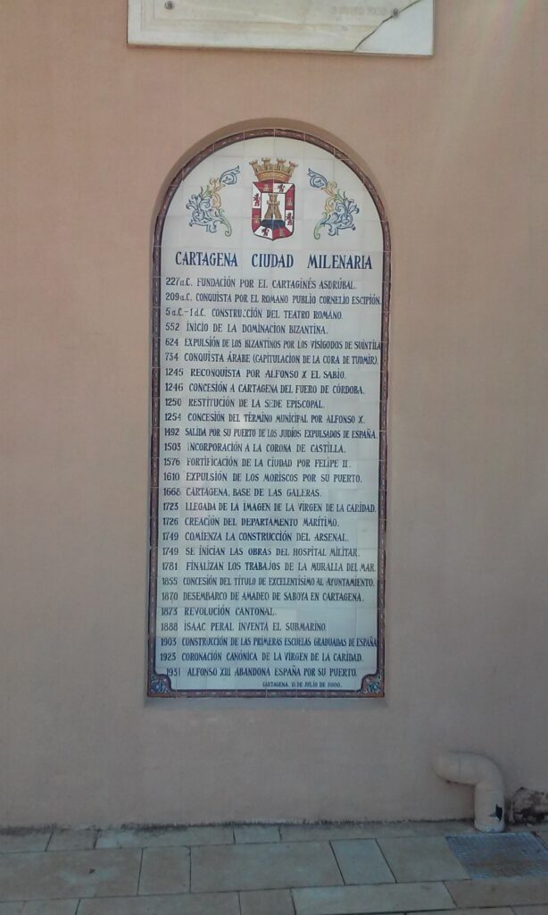 Placa fechada el 15 de julio de 2000 en una calle de la ciudad de Cartagena, con una línea de tiempo detallando fechas como 227 a.C. su fundación por el cartaginés Asdrúbal; 1492 salida por su puerto de los judíos expulsados de España; y 1610 expulsión de los moriscos por su puerto.